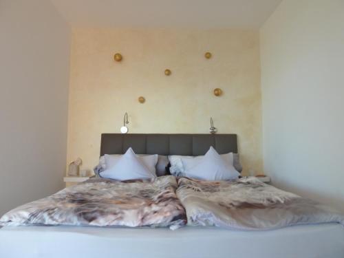 a bedroom with a large bed with white sheets and pillows at Weisse Villa in Millstatt