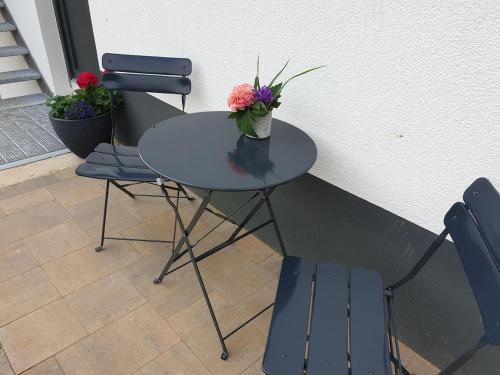 a table with two chairs and a vase with flowers on it at Steinackerhof in Burgthann