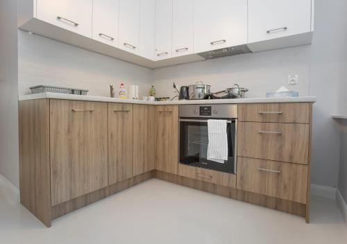 uma cozinha com armários de madeira e um fogão em CR Rodzinny Apartament Chrobrego 16 em Bialystok