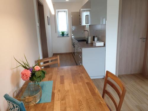 a kitchen and a table with a vase of flowers on it at Steinackerhof in Burgthann