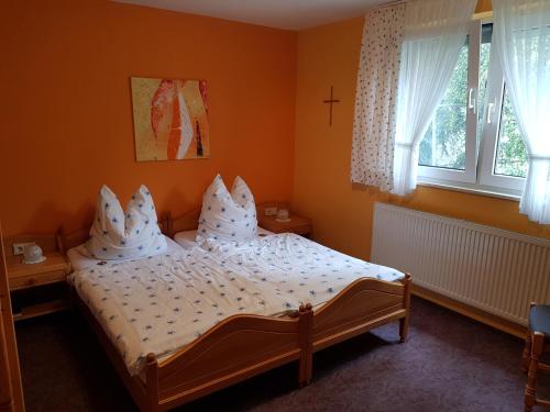 a bedroom with a bed with white sheets and pillows at zur Dorfmühle in Aislingen