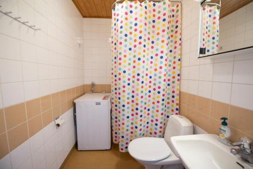 a bathroom with a toilet and a shower curtain at Mikkeli center apartment in Mikkeli