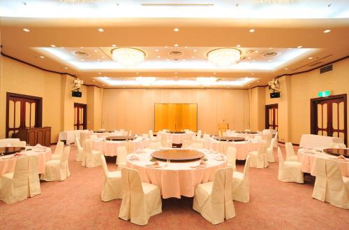 a banquet hall with white tables and white chairs at Niigata Toei Hotel in Niigata