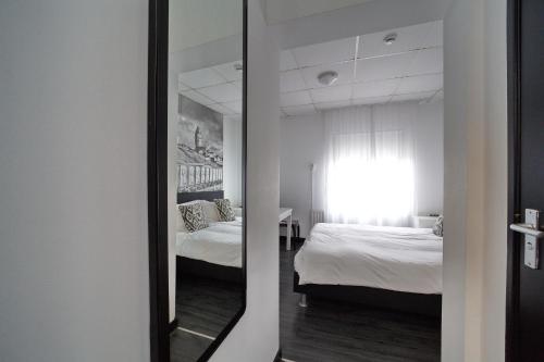 a mirror in a room with two beds at Hotel Zeespiegel in Zandvoort
