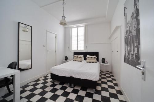 a bedroom with a bed and a checkered floor at Hotel Zeespiegel in Zandvoort