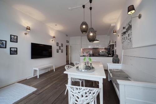 sala de estar blanca con lavamanos y TV en Hotel Zeespiegel en Zandvoort