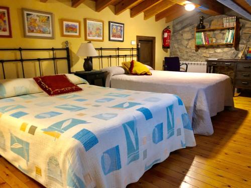 VillahormesにあるEl Pedroso de Llanesの石壁のベッドルーム1室(ベッド2台付)