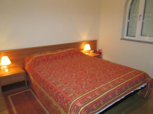 1 dormitorio con 1 cama y 2 lámparas en 2 mesas en Apartments Villa Fernetich, en Premantura