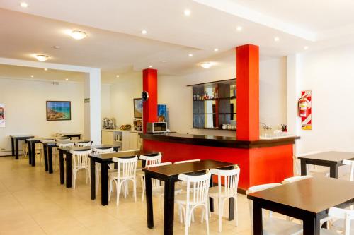 a restaurant with tables and chairs and a bar at Hotel Ramos Mejía in Mar del Plata