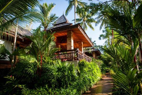 アオナンビーチにあるAonang Phu Pi Maan Resort & Spa - SHA Extra Plusのヤシの木が茂る森の中の小屋