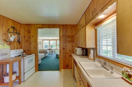 una cucina con pannelli in legno, lavandino e piano cottura di Seventh Street Cottage a Gearhart