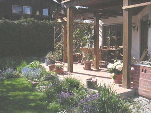 a garden with flowers in a yard with a patio at My sweet home Aptm 80 qm in Sauerlach