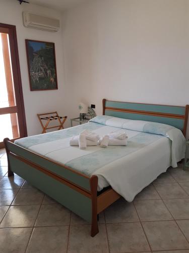 a bedroom with two beds with towels on them at Hotel Il Platano in San Teodoro