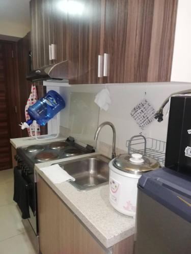a small kitchen with a sink and a stove at Nica's Place Property Management Services at Horizons 101 Condominium in Cebu City