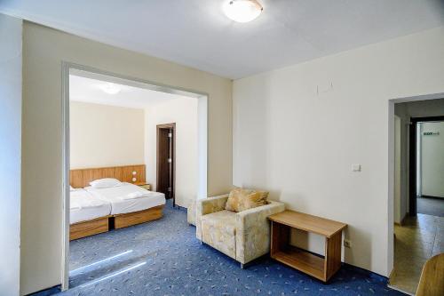 a bedroom with a bed and a chair and a table at International House of Journalists Resort in Golden Sands