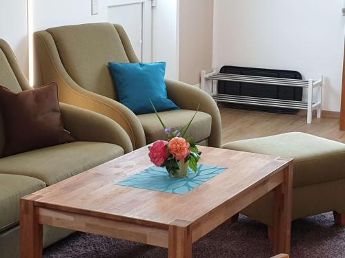 a vase of flowers on a coffee table in a living room at Steinackerhof in Burgthann