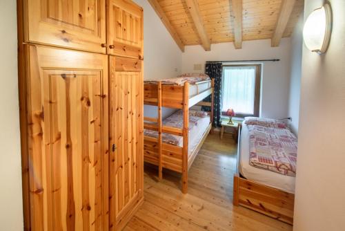 een slaapkamer met 2 stapelbedden in een hut bij Appartamenti Casavacanzepejo in Cogolo