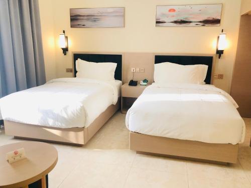 a hotel room with two beds and a table at Season Inn Hotel in Barka