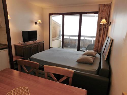 a bedroom with a bed and a table and a window at Les Terrasses d Azur in Isola 2000