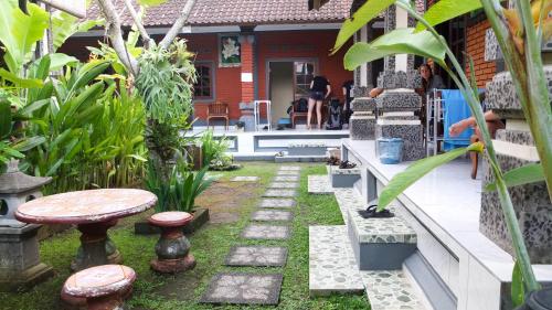 a garden with a table and stool in front of a house at Leket house in Ubud