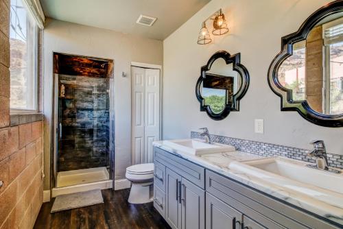 a bathroom with two sinks and a toilet and a mirror at Bella Casa - Loft in Moab