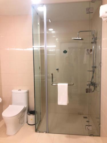 a bathroom with a glass shower with a toilet at Season Inn Hotel in Barka