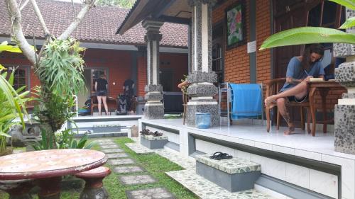 a woman sitting at a table on the porch of a house at Leket house in Ubud