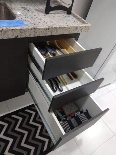 a kitchen counter with a drawer full of wine bottles at Concept Tower Praia Apart in Aracaju