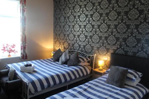 a bedroom with two beds with blue and white at The Vale Apart Hotel in Hull