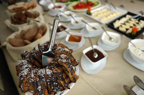 a table topped with plates of food and desserts at Hotel Flower in Tbilisi City