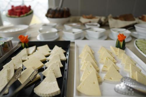 a bunch of cheese on plates on a table at Hotel Flower in Tbilisi City