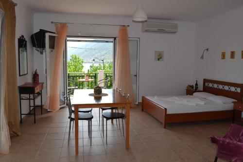 una camera da letto con un tavolo, un letto, un tavolo e delle sedie di Maistrali a Vassiliki
