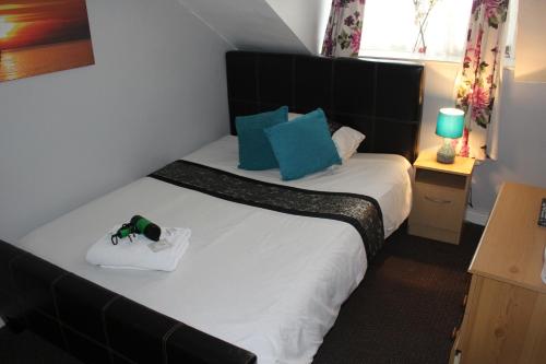 a bedroom with a large bed with blue pillows at The Vale Apart Hotel in Hull