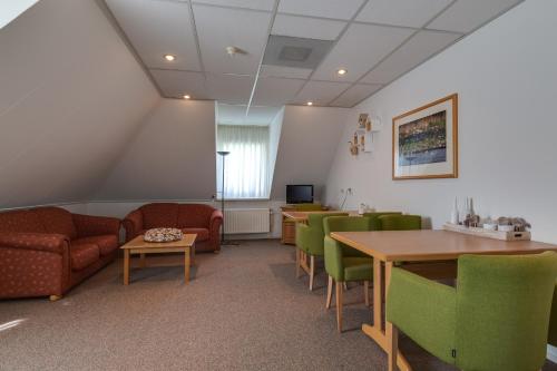 a waiting room with chairs and tables and a couch at HCR Prinsen in Haarlo