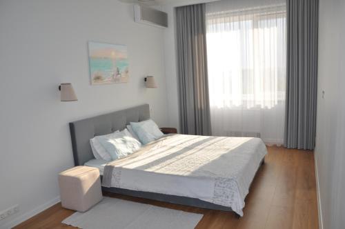 een slaapkamer met een groot bed en een raam bij Sky Apartment in Odessa
