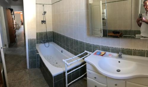 ヴィルヌーヴ・レ・ベジエにあるChambre 2 BEZIERS VILLENEUVEのバスルーム(バスタブ、シンク、鏡付)