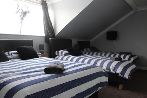 a group of four beds in a room at The Vale Apart Hotel in Hull