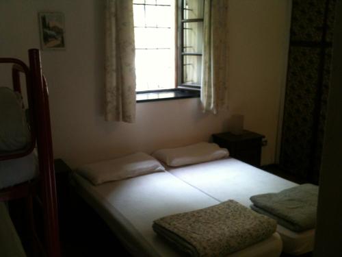 two beds in a room with a window at Casa Nobiallo in Menaggio