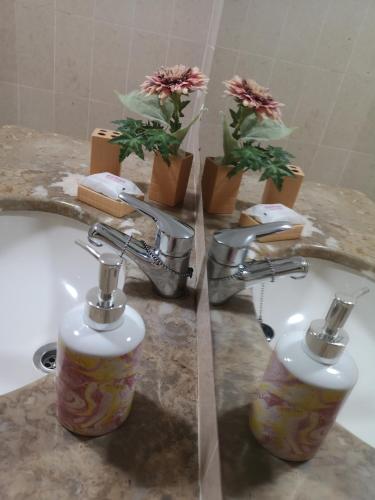 a bathroom with two faucets and a sink with flowers at Architect House in Porto