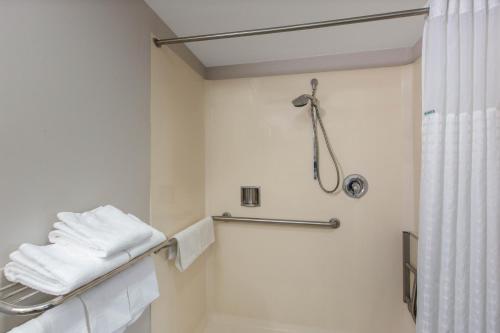 a bathroom with a shower and white towels at Days Inn by Wyndham Ukiah in Ukiah