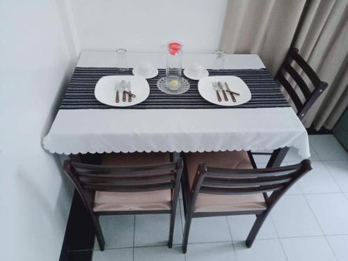 a dining room table with two plates and chairs at De Hagan Transient Baguio City in Baguio