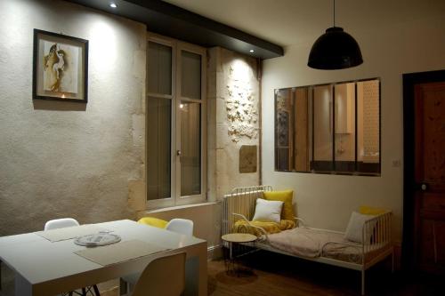 a living room with a table and a chair at Fouras Centre - Meublé Tourisme Classé 3 étoiles in Fouras