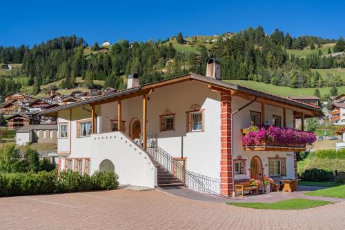 una casa su una collina con una montagna di Artitsch a Santa Cristina in Val Gardena