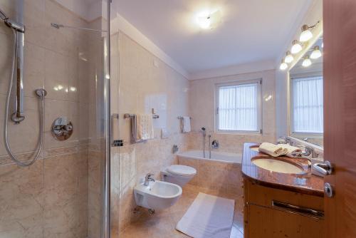 un bagno con doccia, lavandino e WC di Artitsch a Santa Cristina in Val Gardena