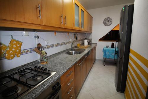 a kitchen with a sink and a stove top oven at NAZARÉ SURF APARTMENT in Nazaré