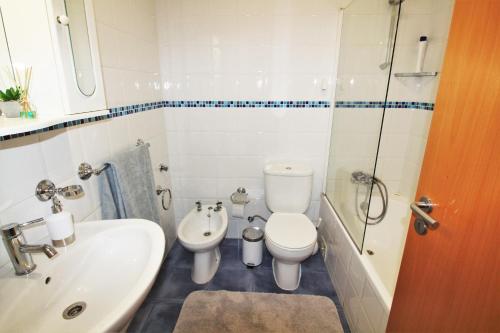 a bathroom with a sink and a toilet and a shower at NAZARÉ SURF APARTMENT in Nazaré
