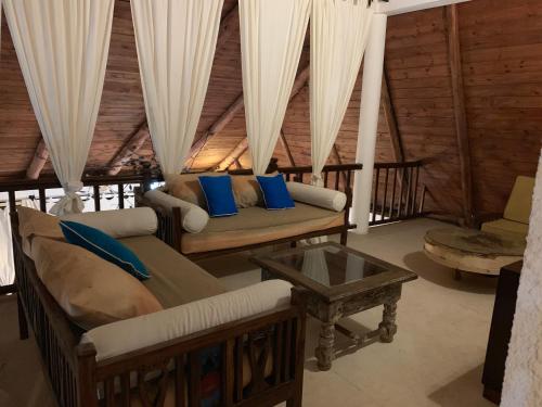 a living room with two couches and a table at Villa Ameera Malindi in Malindi