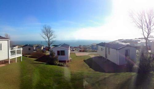 a view of a yard with houses and the ocean at Devon Cliffs in Exmouth