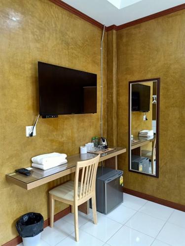 a desk with a television and a chair in a room at Superkids Resort in Phitsanulok