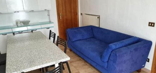 a living room with a blue couch and a table at Casa Guastuglia in Gubbio